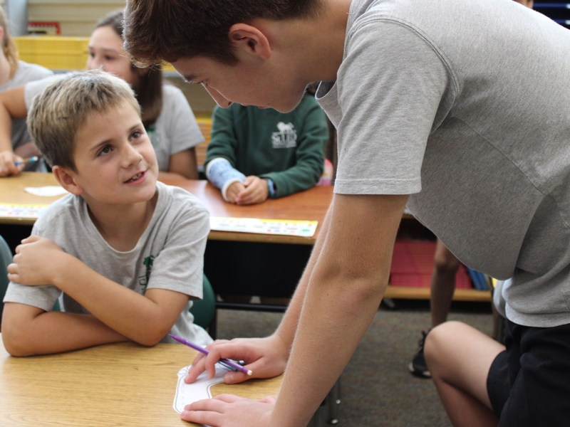 Girl in classroom raising hand